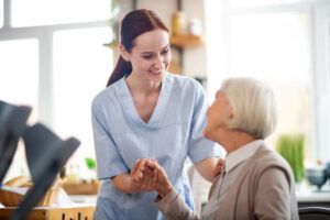 The caregiver helps the patient to stand.